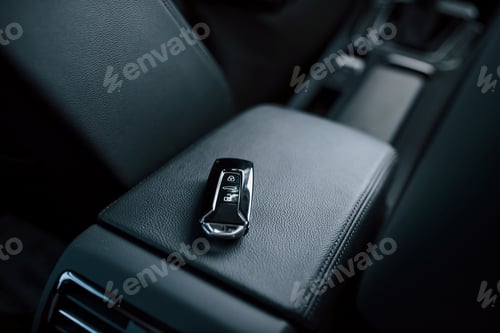 Preview: Close up photo of keys lying donw inside brand new modern car