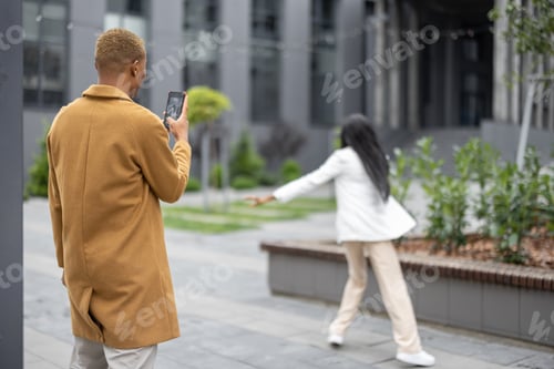 Preview: Man taking photo on smartphone of his girlfriend