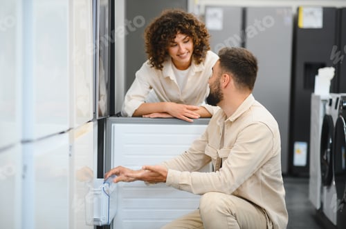 Preview: Couple choosing refrigerator in electronics store