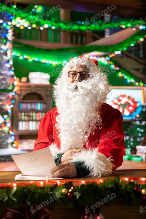 Preview: Santa Claus reading a letter in his cozy festive decorated workshop