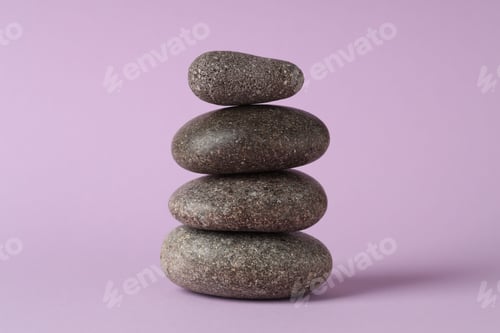 Preview: Stack of rocks on lilac background. Harmony and life balance