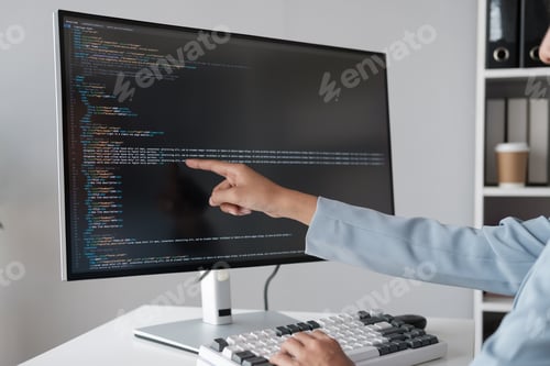 Preview: Close up view of programmer pointing to desktop computer with developing programming code, trying