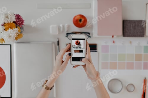 Preview: Woman makes photo on smartphone of beautifully lying office supplies on white background. Photo of