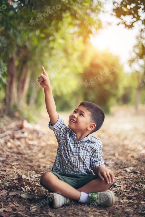 Preview: Happy boy sitting and thinking alone in the park