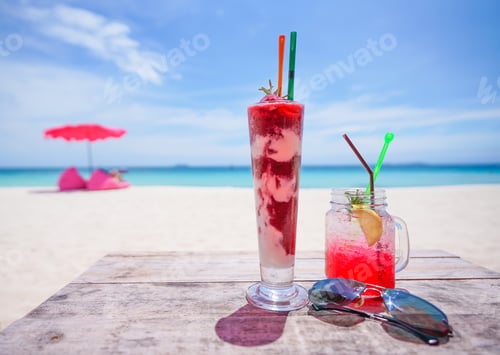 Preview: fresh cold drink on wooden table and Summer background of beach