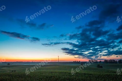Preview: Beautiful sunrise at foggy field in summer