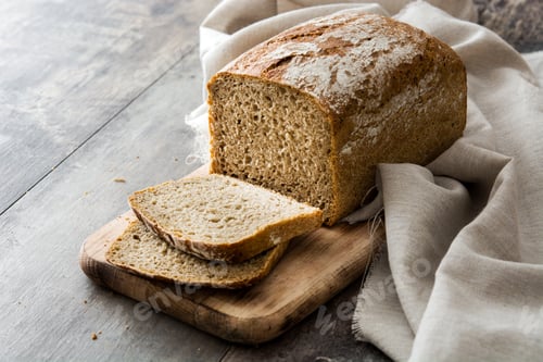 Preview: Loaf of sliced homemade bread resting on rustic wooden board
