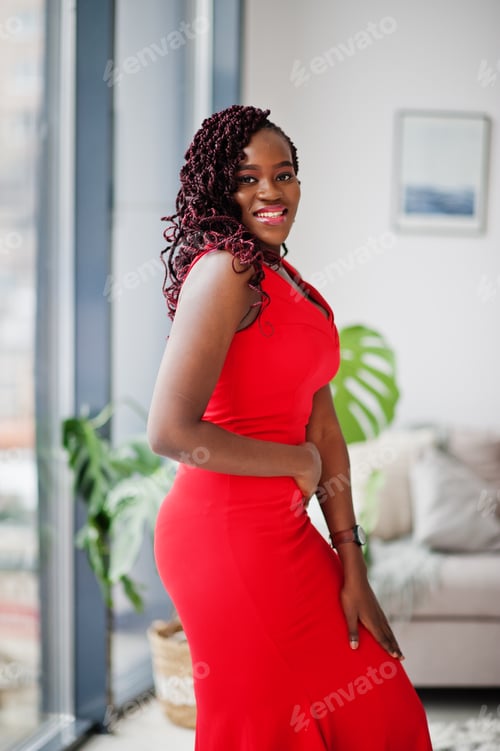 Preview: Magnificent young african woman in luxurious red dress in a luxury apartment. Beauty, fashion.