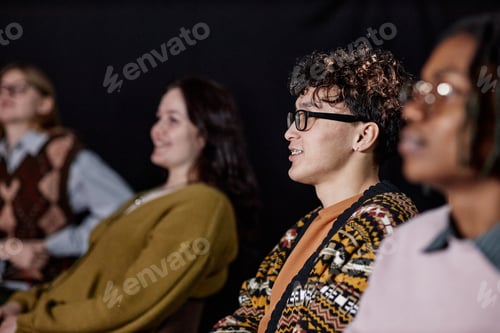 Preview: Multiethnic Young Adults Sitting in Audience Listening Attentively Indoors