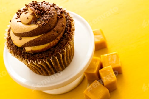 Cupcake with Caramel on a Yellow Background