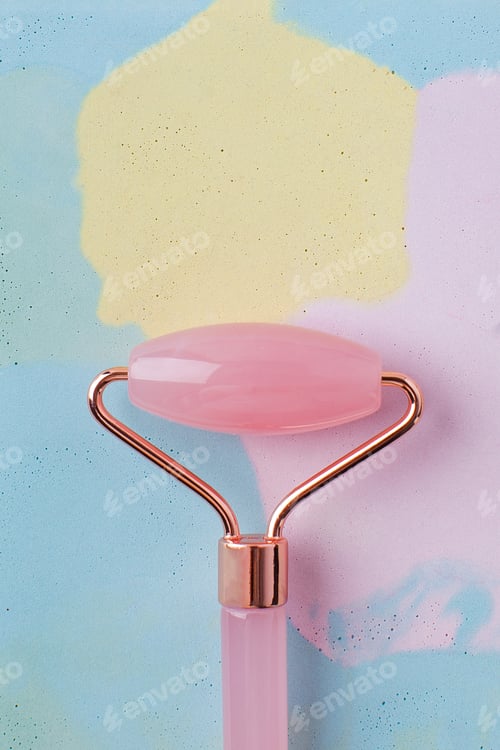 Preview: Face roller jade of pink color close-up. Face care at home, alternative medicine. Copy space.