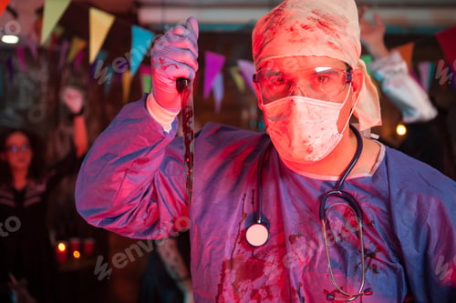 Preview: Scary doctor holding a knife with blood on it at halloween celebration party