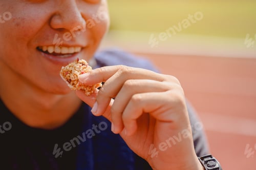 Preview: The young man wore all parts of his body and eatting snack to prepare for jogging on running track