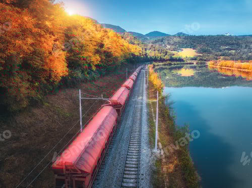 Preview: Aerial view of freight train moving near river in mountains