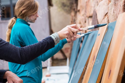 Preview: Teenage girl and her mother painting wooden shelves blue on a terrace