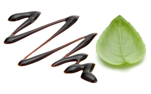 Preview: Balsamic vinegar cream and basil leaves isolated on white background. Italian salad dressing, sauce.