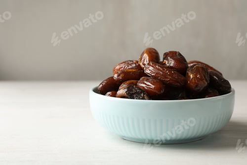 Preview: Bowl with sweet dates on table, space for text. Dried fruit as healthy snack