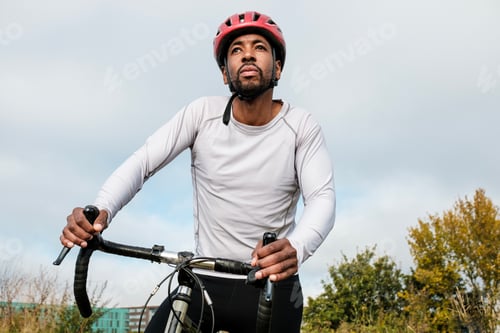 Preview: Cyclist wearing helmet riding bike outdoors and looking up