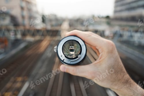 Preview: Train entering frame through handheld lens on railway bridge