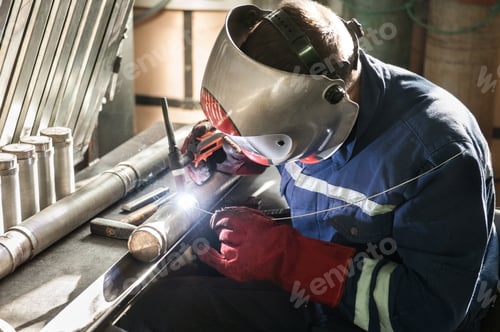 Preview: Closeup of man wearing mask welding in a workshop