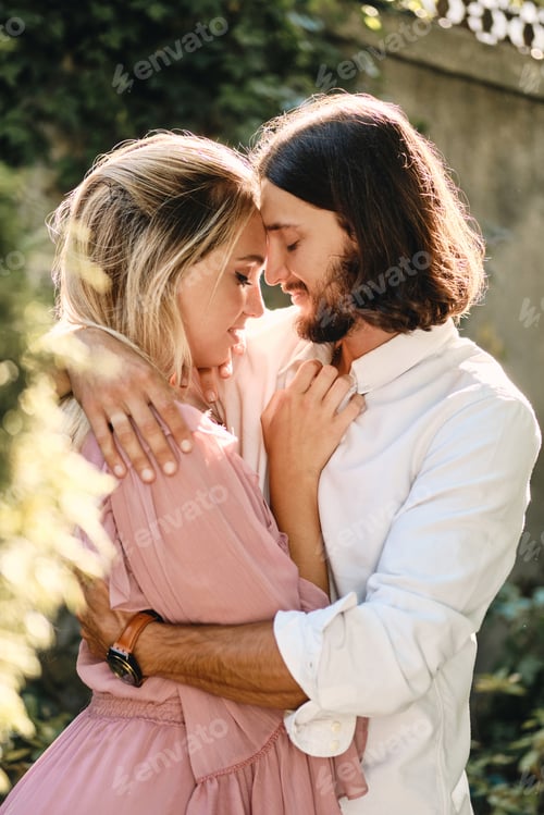 Preview: Portrait of young beautiful romantic couple sensually hugging each other on date outdoor