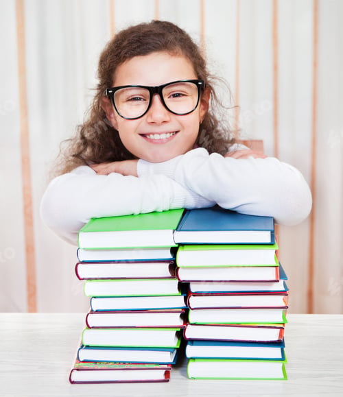 Preview: Little girl wearing glasses with pile of books
