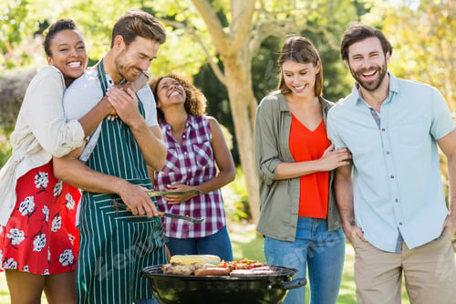 Preview: Happy friends preparing a barbecue grill in park