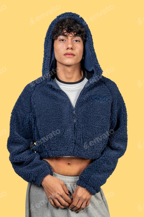 Preview: Young man wearing blue furry cropped hoodie and gray sweatpants posing on yellow background