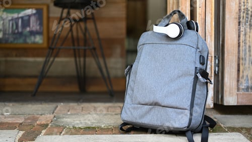 Preview: Tourist backpack and headphones on the road while waiting for the car, Travel concept.
