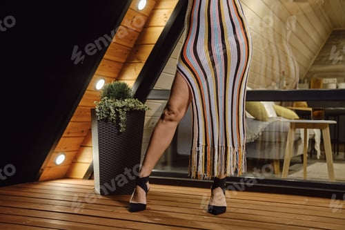 Preview: Cropped image of female legs in high heel shoes and knit beach dress