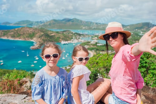 Preview: Mother and kids taking selfie with view of English Harbor from Shirley Heights, Antigua, paradise