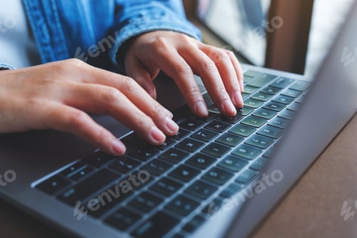 Preview: Closeup image of a woman working and typing on laptop computer keyboard