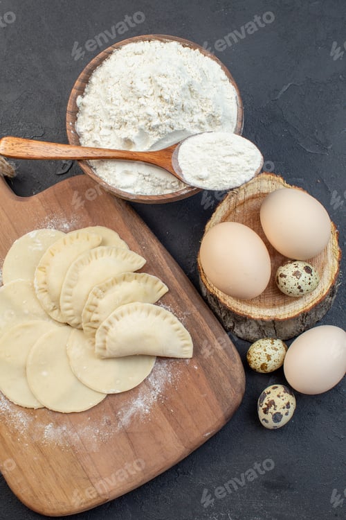Preview: top view raw little hotcakes with flour and eggs on dark background pie dough oven cake bake cooking