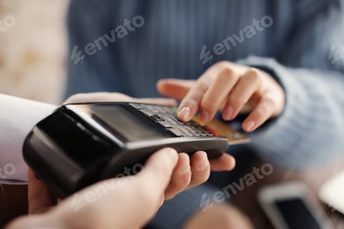 Preview: Woman with credit card using payment terminal at restaurant, closeup
