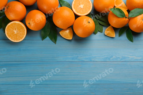 Preview: Delicious ripe oranges on light blue wooden table, flat lay. Space for text