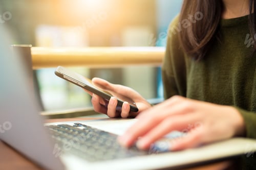 Preview: Woman Connecting Cellphone And Laptop Computer