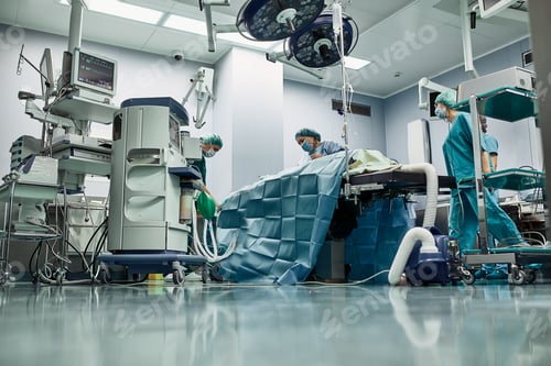 Preview: Surgical team operating on patient in theater in hospital