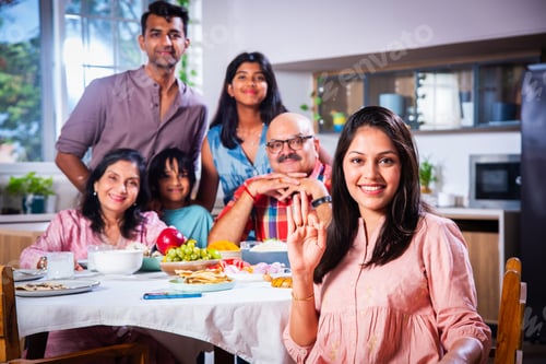 Preview: Happy Indian asian family having lunch at home and posing for photo