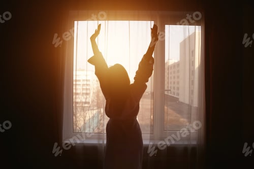 Preview: Sunrise Moment of Joy and Serenity as a Woman Greets the New Day by the Window