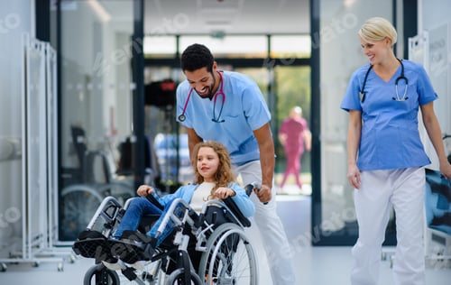Preview: Young multiracial doctor having fun with little girl on wheelchair.