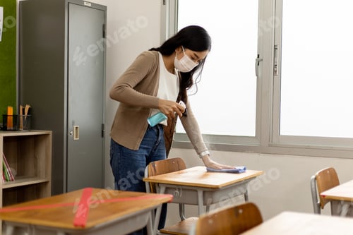 Preview: An Asian woman teacher sprayed alcohol and used a cloth to clean student desks