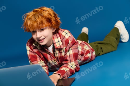 Preview: Creative redhead boy engaged in fashion and fun in a vibrant studio space