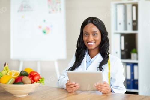 Preview: Young black nutritionist with touch pad creating plant based meal plan for client at clinic, blank