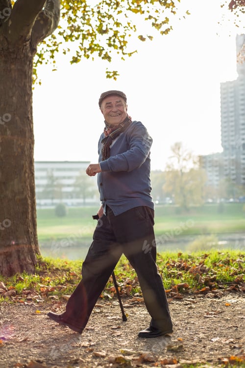 Preview: Happy senior man walking by the riverside