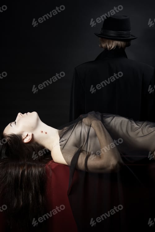 Preview: young beautiful naked girl with a vampire bite on his neck lying on the red fabric, covered with a