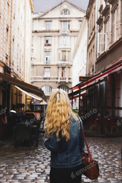 Preview: Woman walking through old European city street