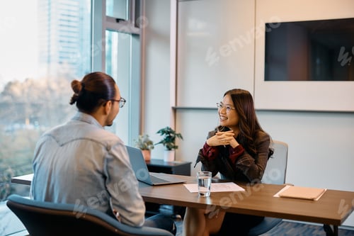 Preview: Happy Asian human resource manager communicating with candidate during job interview in the office.