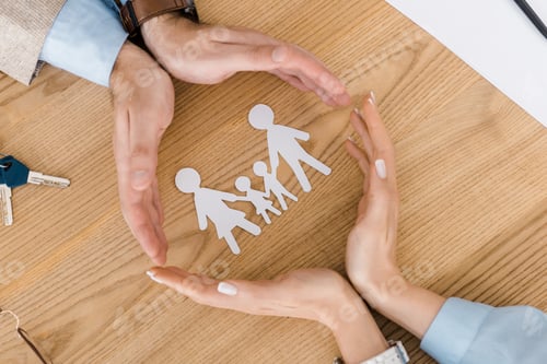 Preview: couple making circle with hands on wooden table with paper people inside