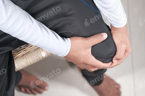 Preview: Close up on man suffering knee joint pain top down