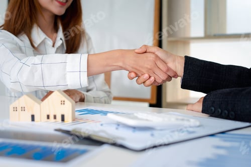 Preview: Real estate agents shakehands to congratulate clients on accepting the offer to buy a home at a spec